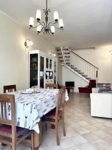 een eetkamer met een tafel en stoelen en een trap bij Sweet Dream House in Carloforte