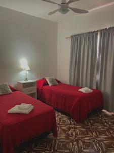 Pokój z 2 łóżkami z czerwoną pościelą i sufitem w obiekcie Los Geranios Apart w mieście Villa Cubas