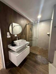 La salle de bains est pourvue d'un lavabo, d'un miroir et d'une douche. dans l'établissement Camelia Chincha® Hermosa Casa de Playa y Campo, à San Pablo