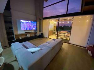 salon z białą kanapą i telewizorem w obiekcie Camelia Chincha® Hermosa Casa de Playa y Campo w mieście San Pablo