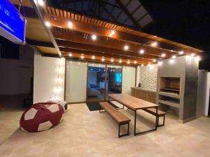 Habitación con mesa, banco y luces. en Camelia Chincha® Hermosa Casa de Playa y Campo en San Pablo