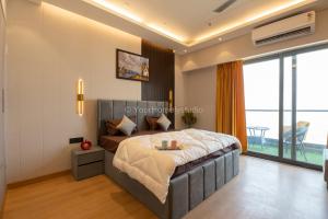 um quarto com uma cama e uma grande janela em Luxury Grand Mansion: YourHomelystudio em Ghaziabad