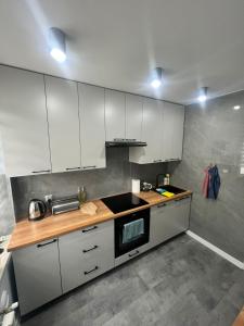 una cucina con armadi bianchi e ripiano in legno di Apartament na wyłączność plus Prywatny Parking a Pyskowice