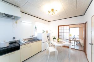 Corpo Shinkai 203 - Vacation STAY 16660 في سوزوكا: مطبخ مع دواليب بيضاء وطاولة مع غرفة طعام