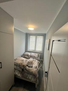 una piccola camera con letto e finestra di Apartament na wyłączność plus Prywatny Parking a Pyskowice