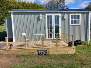 a deck in front of a tiny house at The Mad Hatter's Hut in Carlisle