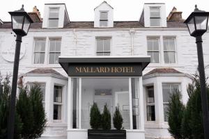 biały budynek z znakiem hotelu w obiekcie The Mallard Hotel w mieście Gullane