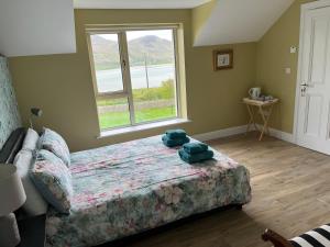 a bedroom with a bed with two blue towels on it at Robins Nest in Ardara