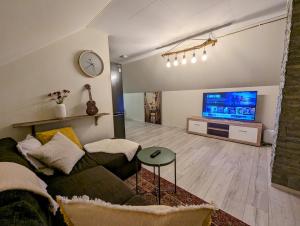 a living room with a couch and a flat screen tv at Countryside experience in a Cozy Loft Near Bergen in Frekhaug