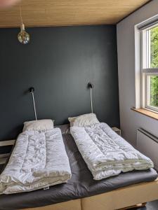 two beds in a bedroom with a wall at Landstedet in Gram