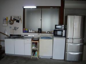 W kuchni znajduje się biała lodówka i kuchenka mikrofalowa. w obiekcie Minpaku KEN HOUSE - Vacation STAY 60948v w mieście Nagahama