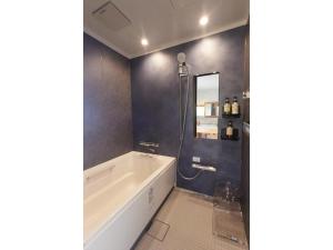 高知市にあるStay UWU 001 - Vacation STAY 61220vのバスルーム(バスタブ、鏡付きシャワー付)