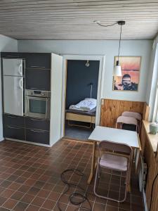 a kitchen with a table and a bed in a room at Landstedet in Gram