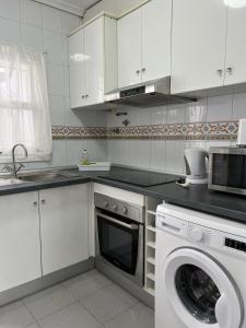 een keuken met een wasmachine en een wasmachine bij LOS1-VAO Holiday Rentals- Los Alcazares near Roda Roundabout in Los Alcázares