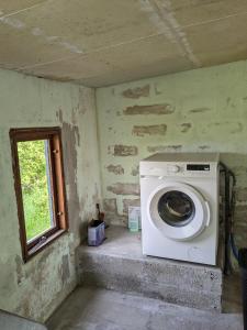 a washing machine in a room with a window at Landstedet in Gram