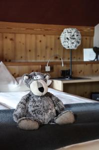 un ours en peluche assis au-dessus d'un lit dans l'établissement Hotel Ehrwalderhof, à Ehrwald