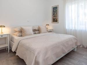 a white bedroom with a white bed and a window at Hvar Pavičić Top View apartments in Hvar