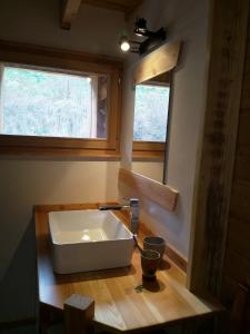 un grand lavabo blanc dans une pièce avec deux fenêtres dans l'établissement Le grenier du Roux, à Abriès 15 autres photos