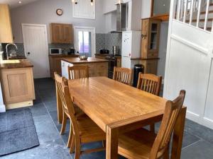 a kitchen with a wooden table and wooden chairs at Tregue Cottage in Camelford +11 photos
