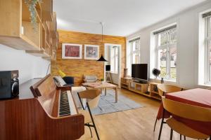 een woonkamer met een piano en een tafel bij Spacious 3-Bedroom Apartment for 8 by Bryggen in Bergen