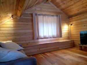 - une chambre avec une fenêtre dans une cabane en rondins dans l'établissement Le grenier du Roux, à Abriès