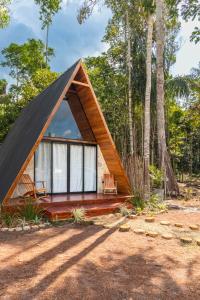 uma cabana na floresta com um telhado preto em Cabana Ewaré em Presidente Figueiredo