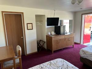 um quarto de hotel com uma televisão numa cómoda com um quarto em VISTA VILLA MOTEL em Ludington