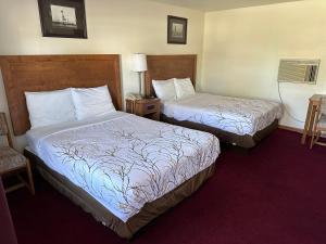 une chambre d'hôtel avec deux lits et une chaise dans l'établissement VISTA VILLA MOTEL, à Ludington