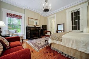 een slaapkamer met een bed en een open haard bij Cromwell Manor Inn in Cornwall-on-Hudson