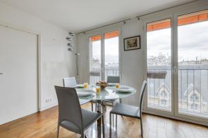 a dining room with a table and chairs and a balcony at Superb & Luminous T4 apartment in Montmartre in Paris