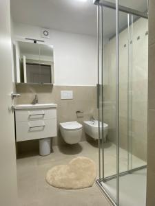 a bathroom with a toilet and a sink and a shower at Appartamento al Gallo con terrazzo in Arco +8 photos