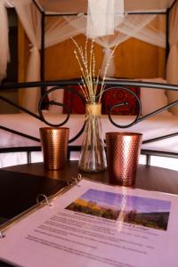 a table with two candles and a paper on it at Quiet Mind Lodge, Spa & Retreat Sequoias in Kernville