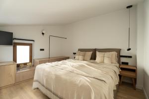 a bedroom with a large bed and a television at Cortiletto Timeless Suites in Rethymno Town
