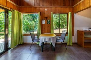 Habitación con mesa, sillas y ventanas. en Campo Verde B&B - Monteverde Costa Rica en Monteverde Costa Rica
