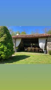 une maison avec un patio avec une table et des chaises dans l'établissement Cottage River & Spa, à Saint-Ilpize