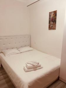 a bed with white sheets and two towels on it at Old tbilisi in Tbilisi City