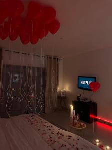 Schlafzimmer mit roten Ballons über einem Bett in der Unterkunft Studio indépendant Valbonne proche Cannes in Valbonne