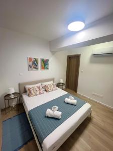 a bedroom with a large bed with towels on it at Lazarus Oasis in Larnaca