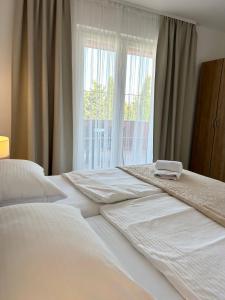 sypialnia z dużym białym łóżkiem i oknem w obiekcie Apartments Mare w mieście Punat