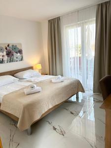 a bedroom with two beds and a large window at Apartments Mare in Punat