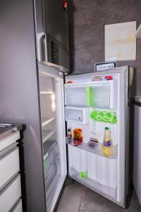 um frigorífico aberto com a sua porta aberta e comida no interior em Casa aconchegante em Goiânia em Goiânia