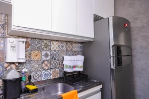 uma pequena cozinha com um lavatório e um frigorífico em Casa aconchegante em Goiânia em Goiânia