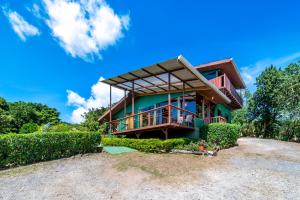 una casa rodeada de un porche y arbustos en Campo Verde B&B - Monteverde Costa Rica en Monteverde Costa Rica