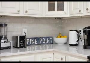 a kitchen counter with a pineapple point sign on it at Seaside Serenity, Your Pine Point Beach Paradise in Scarborough