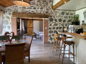 une cuisine et une salle à manger avec un mur en pierre dans l'établissement Cottage River & Spa, à Saint-Ilpize