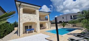 uma villa com uma piscina e uma casa em Villa Martina em Pinezici