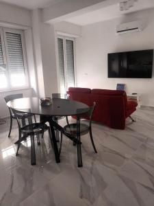 een woonkamer met een tafel en een rode bank bij Cuore di Napoli Centro in Napels