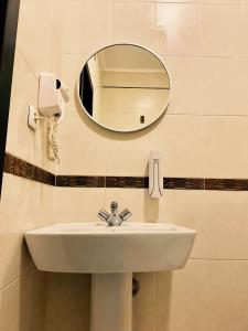 a bathroom sink with a mirror and a phone at Отель Ренессанс in Dnipro