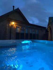 una piscina frente a una casa por la noche en The Apple Press - Sweethay en Taunton