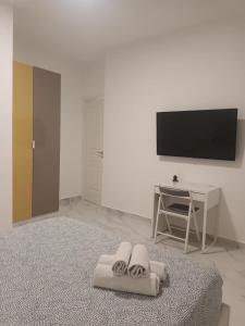 um quarto branco com uma cama e uma televisão de ecrã plano em Cuore di Napoli Centro em Nápoles